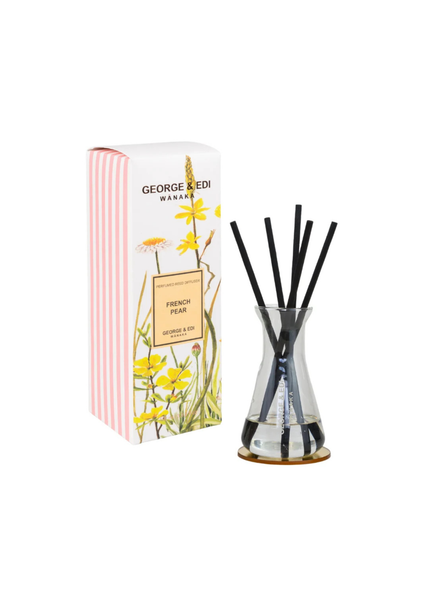 George & Edi reed diffuser in 'French Pear' scent, featuring a clear glass bottle with black reeds and a striped pink and white packaging box with yellow dandelion illustrations, set against a plain white background.