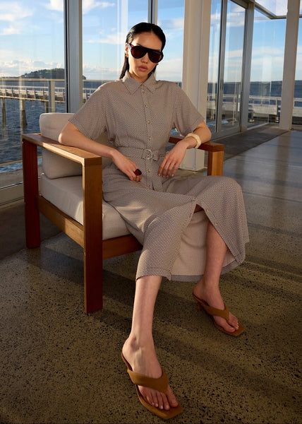 Model sitting on a chair while wearing Marlow Axis dress in prism print